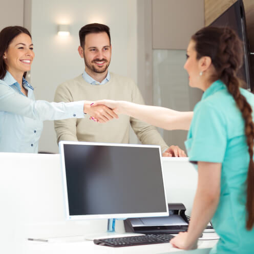 A dental receptionist greeting patients